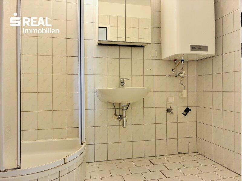 Badezimmer mit Dusche und Waschmaschinenanschluss