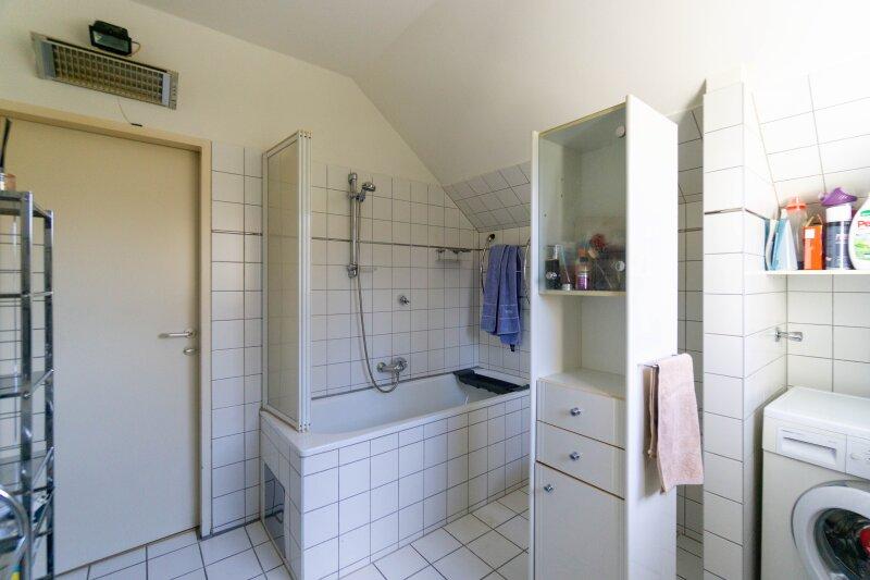 Badezimmer mit Wanne und Waschmaschinenanschluss