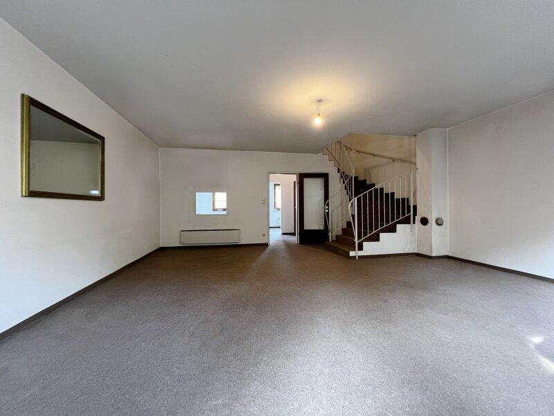 Wohnzimmer mit Stiege in das Dachgescho