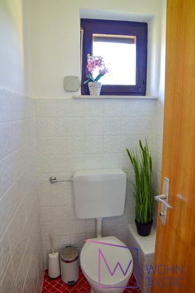 separates WC mit Waschbecken und Fenster