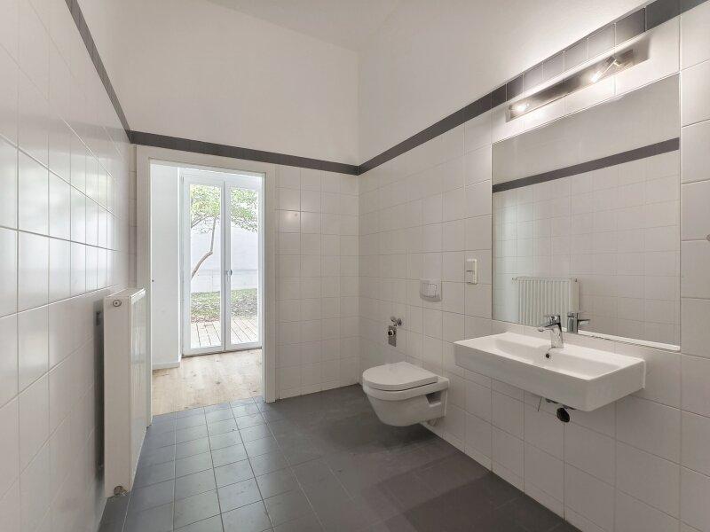 Badezimmer mit Blick in den Vorraum und Garten