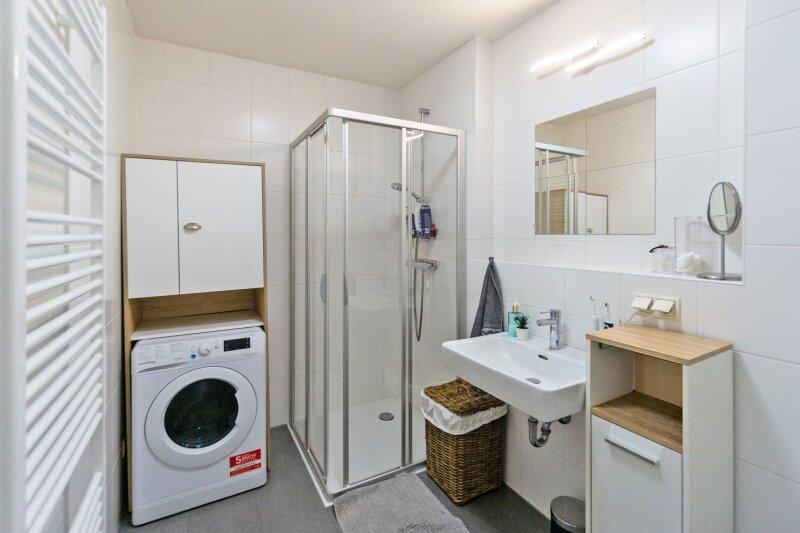 Badezimmer mit Dusche und Waschmaschinenanschluss