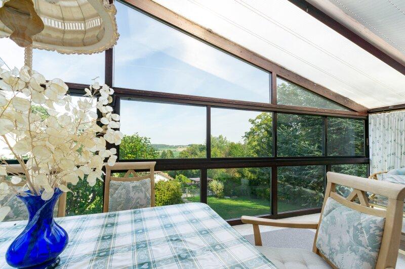 Wintergarten mit Ausblick in den Garten und die Ferne